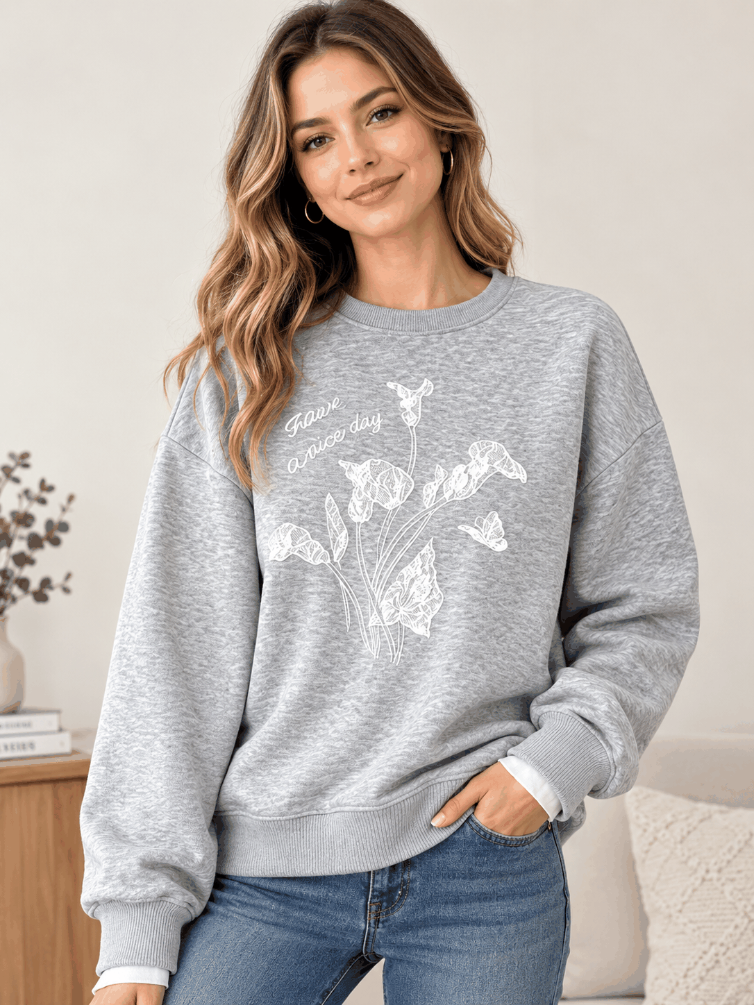 Woman wearing a gray floral crew neck sweatshirt with jeans